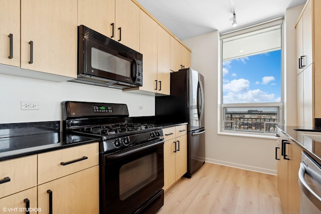 kitchen with black appliances, light brown cabinetry, dark countertops, and light wood-style flooring