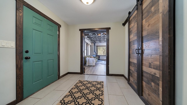 foyer entrance featuring light tile patterned flooring and a barn door