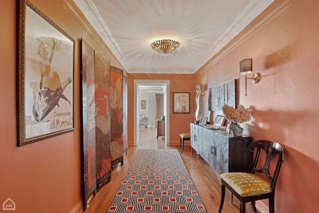 hallway featuring light wood-type flooring and ornamental molding