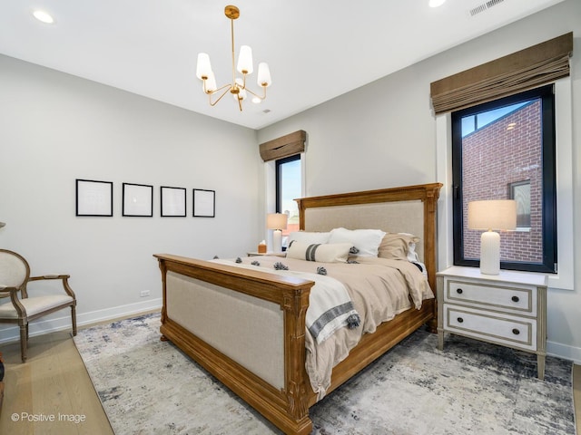 bedroom featuring an inviting chandelier and wood-type flooring