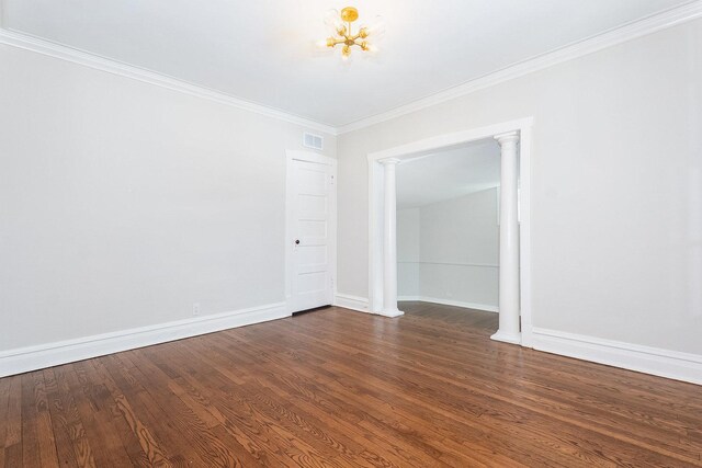 empty room with visible vents, crown molding, baseboards, and wood finished floors