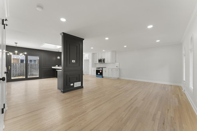 unfurnished living room with light hardwood / wood-style flooring and crown molding