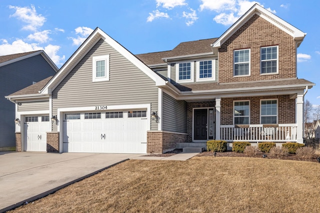 view of front facade with a porch, a garage, brick siding, driveway, and a front lawn