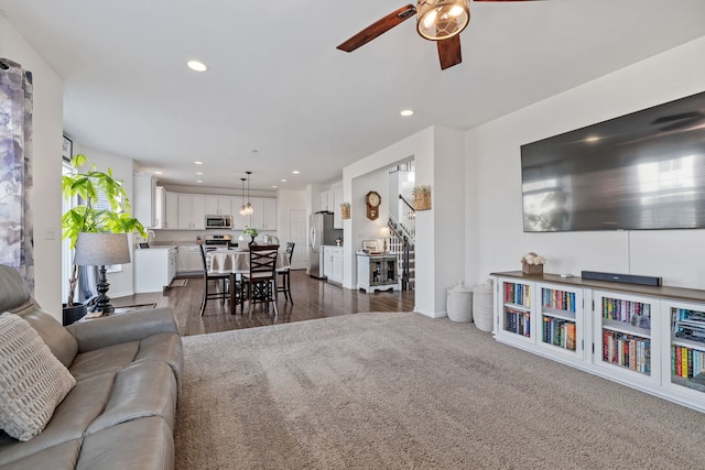 living room featuring stairs, dark carpet, a ceiling fan, and recessed lighting