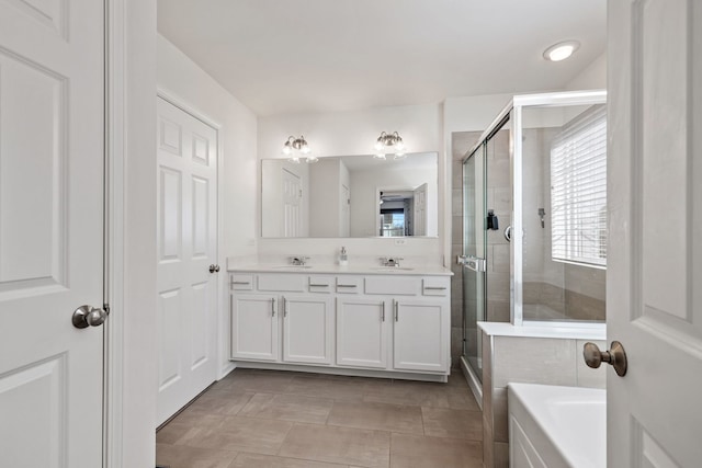 bathroom with double vanity, a stall shower, a sink, and a bath