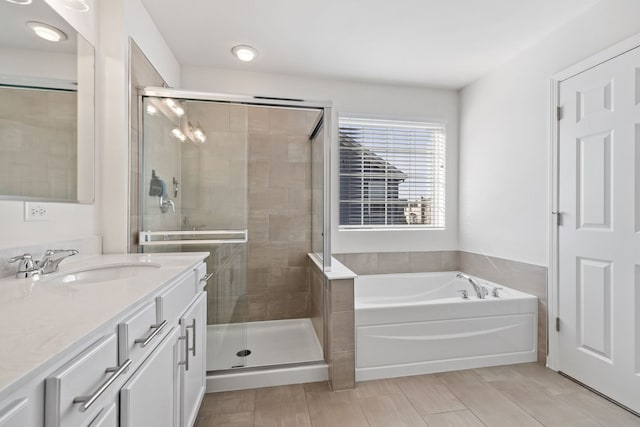 full bathroom featuring a stall shower, a garden tub, and vanity