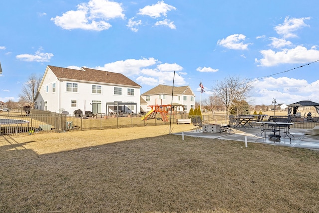 communal playground with fence, a lawn, and a patio