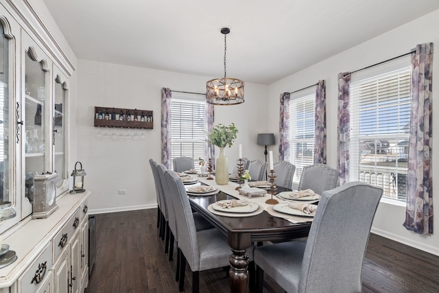 dining space with dark wood-style flooring, a notable chandelier, and baseboards