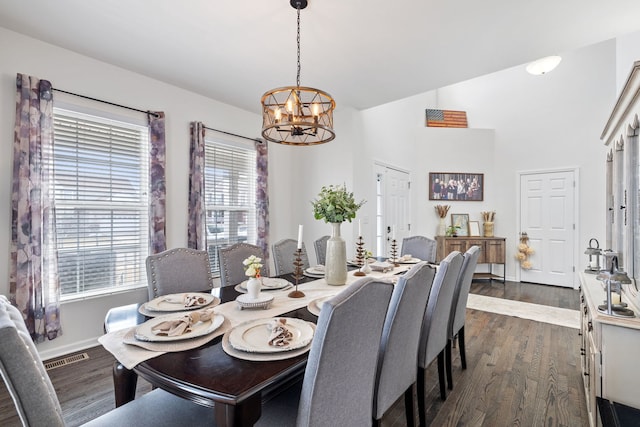 dining space with a notable chandelier, dark wood finished floors, and baseboards