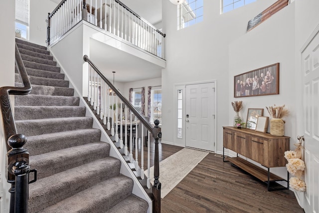 foyer with baseboards, stairway, dark wood-style flooring, and a healthy amount of sunlight