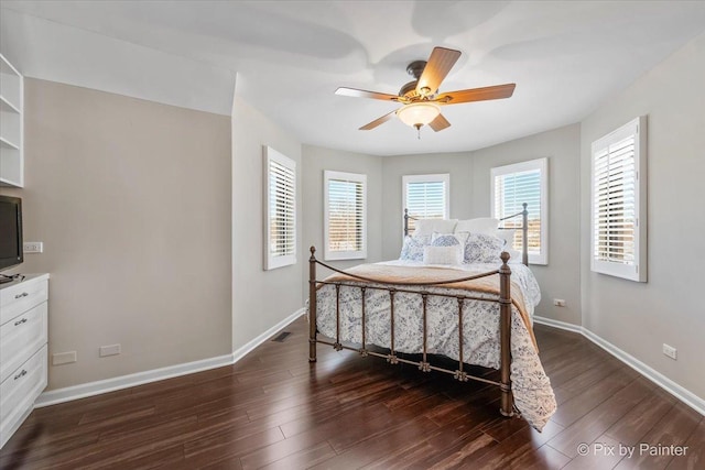 bedroom featuring dark wood-style floors, visible vents, a ceiling fan, and baseboards