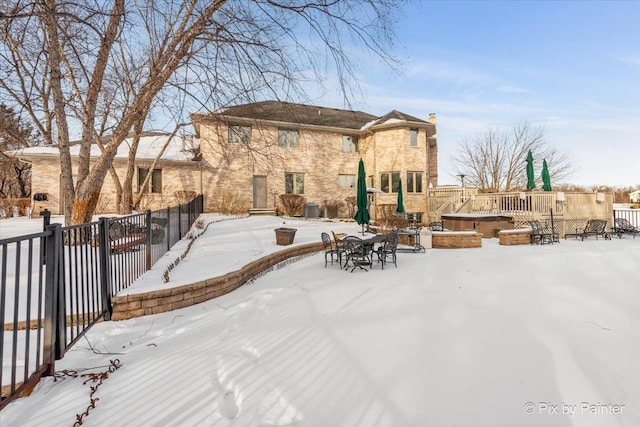 snow covered patio featuring cooling unit and fence