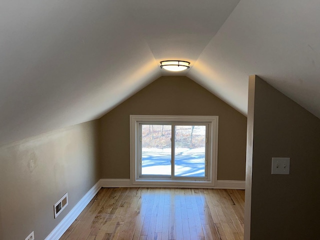 additional living space with lofted ceiling and light hardwood / wood-style flooring