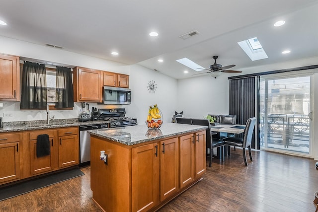 kitchen with dark stone counters, stainless steel appliances, a sink, and visible vents