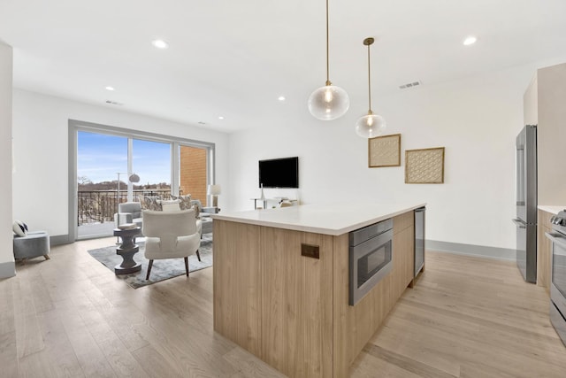 kitchen with visible vents, light wood-style flooring, modern cabinets, appliances with stainless steel finishes, and light countertops