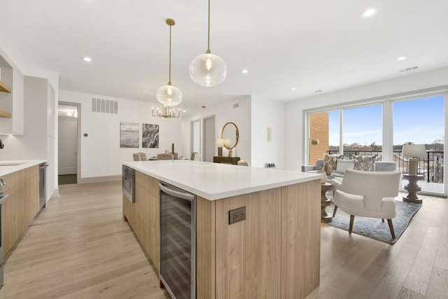 kitchen with wine cooler, modern cabinets, light wood-style flooring, and visible vents