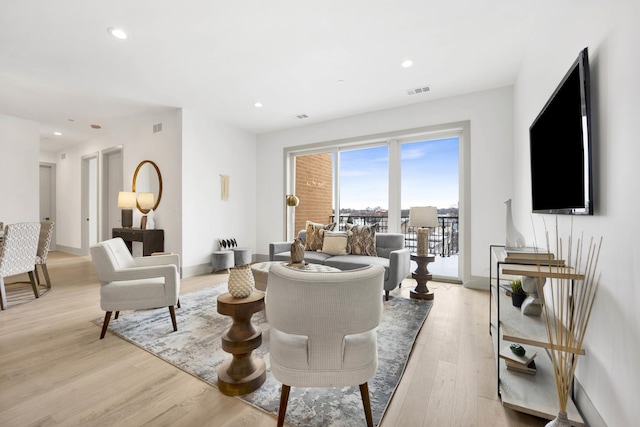 living area featuring baseboards, light wood-style flooring, and recessed lighting