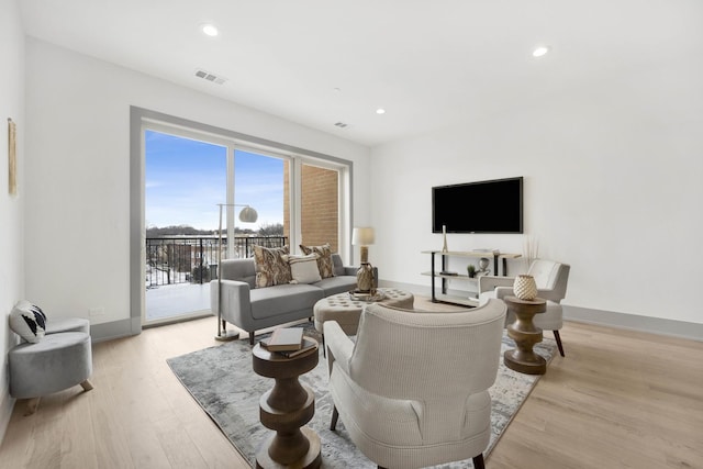 living room with baseboards, light wood-style flooring, visible vents, and recessed lighting