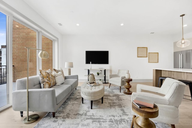 living area with light wood finished floors, a fireplace, visible vents, and recessed lighting