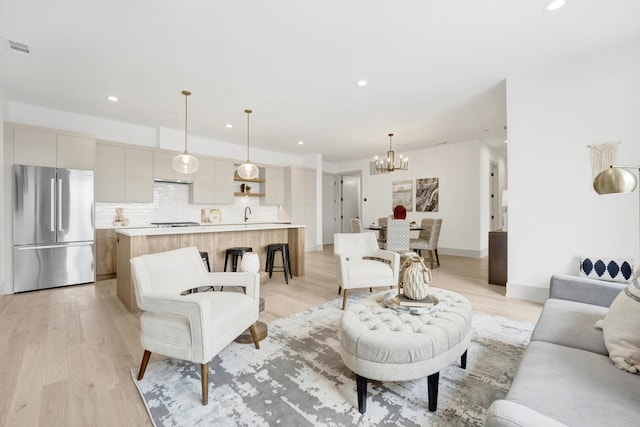 living area with light wood-style flooring, visible vents, a chandelier, and recessed lighting