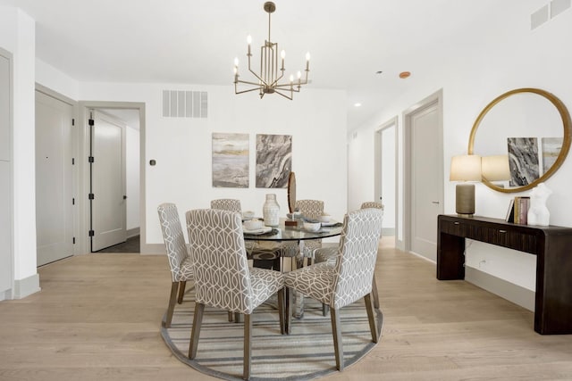 dining space featuring a chandelier, light wood-type flooring, and visible vents