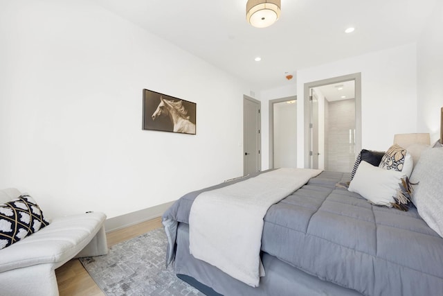 bedroom featuring baseboards, wood finished floors, and recessed lighting