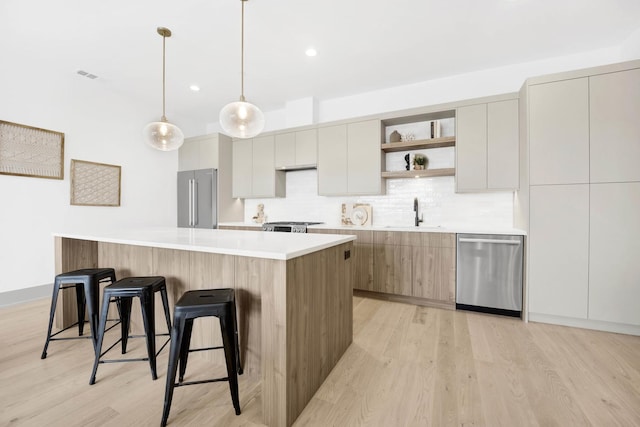 kitchen with modern cabinets, appliances with stainless steel finishes, open shelves, and a sink