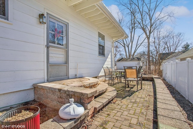 view of patio with outdoor dining area, an outdoor structure, and a fenced backyard