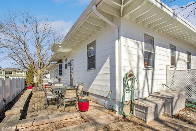 view of side of property with a patio area, outdoor dining space, and a fenced backyard