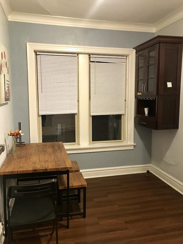 dining area with dark hardwood / wood-style flooring and crown molding