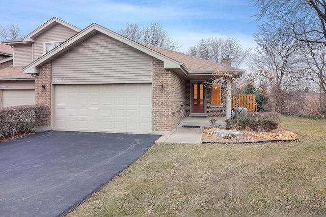 view of front of property with a garage, brick siding, driveway, a front lawn, and a chimney