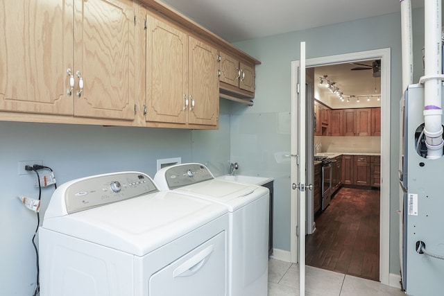 laundry room featuring light tile patterned floors, a sink, washing machine and dryer, and cabinet space