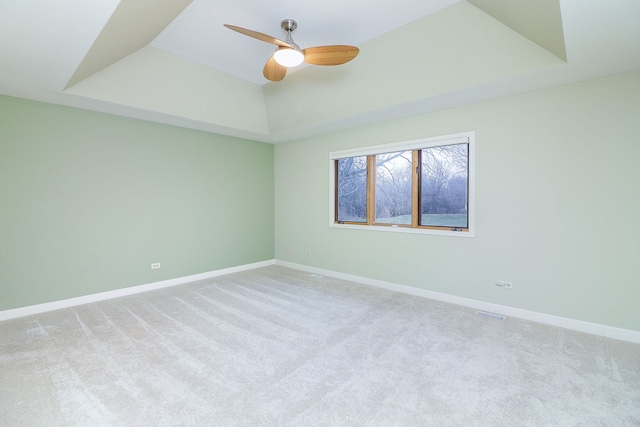 spare room with a tray ceiling and baseboards