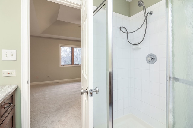 full bath with baseboards, vanity, and a shower stall