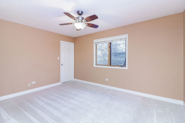 spare room featuring light colored carpet, visible vents, and baseboards