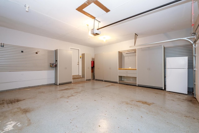 garage featuring a garage door opener and white refrigerator