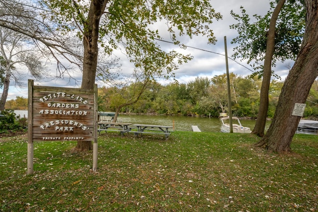 view of home's community featuring a water view and a lawn