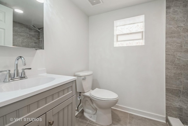 bathroom featuring toilet, vanity, tile patterned flooring, and a shower