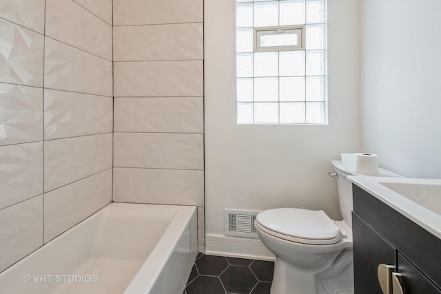 bathroom with toilet, vanity, and tile patterned flooring