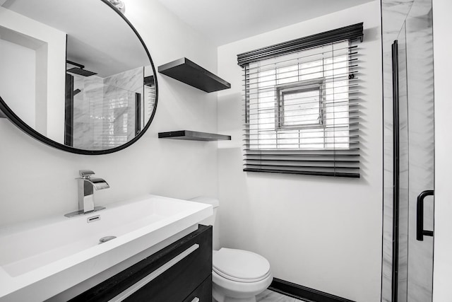 bathroom with vanity, toilet, and a shower with shower door