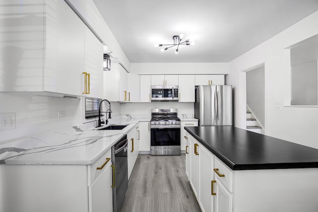 kitchen featuring white cabinetry, stainless steel appliances, light hardwood / wood-style flooring, sink, and light stone counters