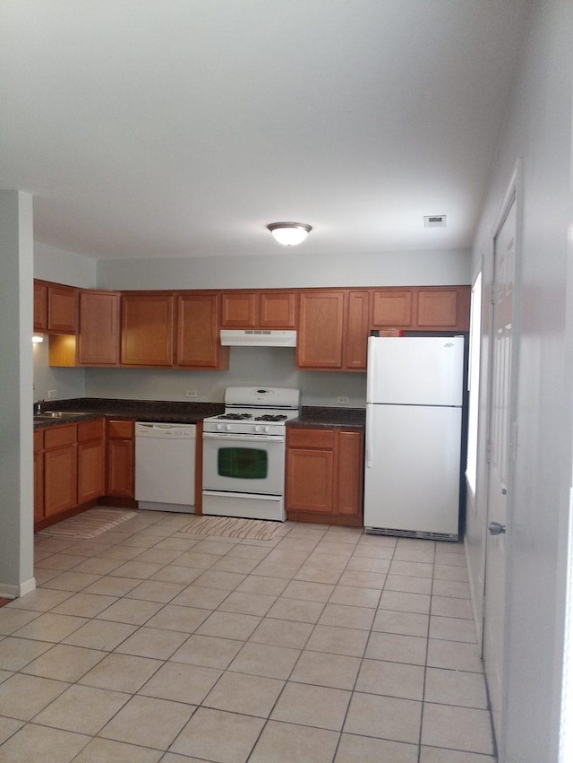 kitchen featuring light tile patterned flooring and white appliances