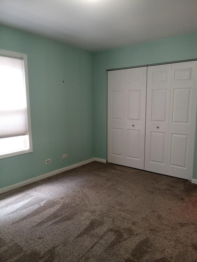 unfurnished bedroom with a closet and carpet floors