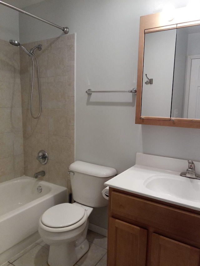 full bathroom with tiled shower / bath, tile patterned flooring, vanity, and toilet