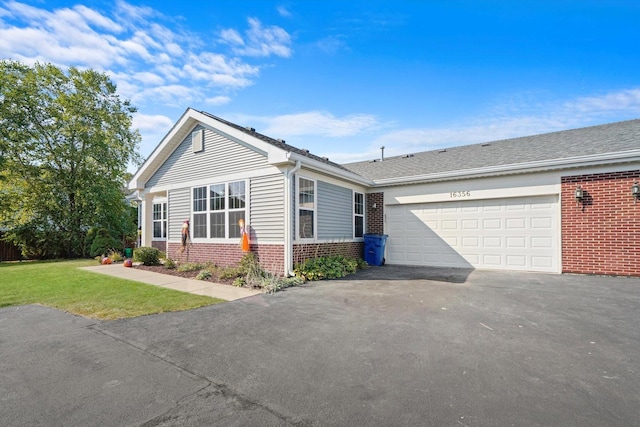 ranch-style house featuring a front yard and a garage