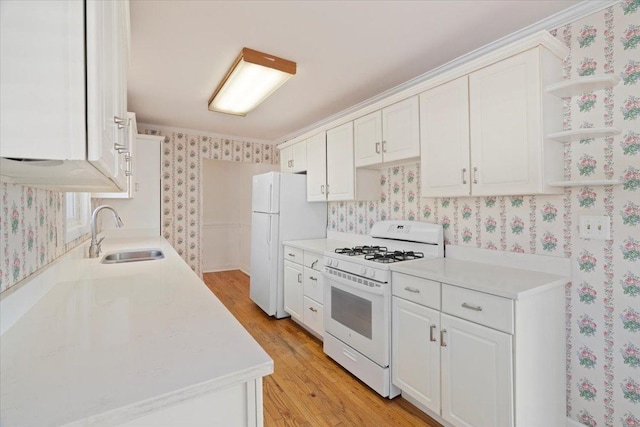 kitchen featuring open shelves, white cabinetry, a sink, white appliances, and wallpapered walls