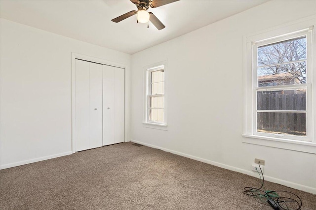 unfurnished bedroom with carpet floors, visible vents, baseboards, and a closet