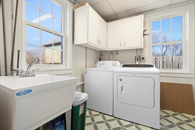 laundry room with a sink, cabinet space, washing machine and dryer, and light floors