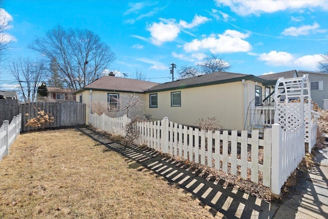 view of property exterior with a fenced front yard and a yard