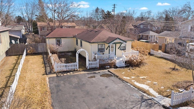 view of front facade with a fenced front yard, a residential view, a gate, and aphalt driveway